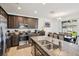 Modern kitchen with stainless steel appliances, granite counters, island seating, and adjacent dining area at 37820 Beacon Brick Dr, Zephyrhills, FL 33540