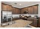 Modern kitchen features stainless appliances, granite countertops, a large island and dark wood cabinetry at 37820 Beacon Brick Dr, Zephyrhills, FL 33540