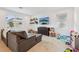 Cozy living room with a comfortable gray couch, wall-mounted TV, and ample natural light at 37820 Beacon Brick Dr, Zephyrhills, FL 33540