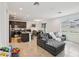 Open-concept living space with gray couch, dining area, and modern kitchen with stainless appliances at 37820 Beacon Brick Dr, Zephyrhills, FL 33540