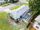 Home with screened-in pool, fenced yard, and mature landscaping, viewed from above at 410 N Corona Ave, Clearwater, FL 33765