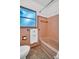 Vintage bathroom with original peach-colored tiles, bath tub, and toilet at 410 N Corona Ave, Clearwater, FL 33765