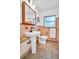 Vintage bathroom with pedestal sink, tile floors, toilet, and large framed mirror at 410 N Corona Ave, Clearwater, FL 33765