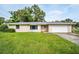Charming single-story home with a well-maintained lawn and a classic suburban design at 410 N Corona Ave, Clearwater, FL 33765