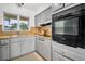 Functional kitchen features light gray cabinetry, modern appliances, and a charming window view at 410 N Corona Ave, Clearwater, FL 33765