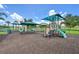 Community playground with slides, climbing structures, and sunshades on a mulched surface at 4151 Little Gap Loop, Ellenton, FL 34222