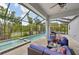 A covered pool area with comfortable seating and travertine floor at 4151 Little Gap Loop, Ellenton, FL 34222