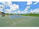 Community tennis court with green and blue surface, surrounded by greenery and lights at 4151 Little Gap Loop, Ellenton, FL 34222