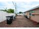 Backyard area featuring brick pavers, a covered patio, and a black trash container at 4403 W Minnehaha St, Tampa, FL 33614