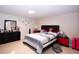 Bedroom with a bed with padded headboard, and red accents on the dressers at 4403 W Minnehaha St, Tampa, FL 33614