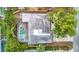 Aerial view of a home with a screened-in pool, neutral roof, mature trees, and established landscaping at 4419 W El Prado Blvd, Tampa, FL 33629