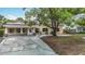Attractive single-story home boasting a manicured lawn, mature tree, and welcoming covered porch at 4419 W El Prado Blvd, Tampa, FL 33629
