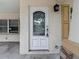 Close-up of an ornate glass front door with a charming exterior light fixture and stone-accented columns at 4419 W El Prado Blvd, Tampa, FL 33629