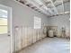 Garage featuring a water heater, exposed ceiling beams, and a white door at 4419 W El Prado Blvd, Tampa, FL 33629