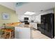 Contemporary kitchen equipped with stainless steel appliances, white cabinetry, and stylish breakfast bar at 4510 Gulf Blvd # 604, St Pete Beach, FL 33706