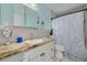 Bathroom featuring a vanity with granite countertop and shower with a sea-themed curtain at 5700 Pacific N St, St Petersburg, FL 33703
