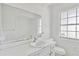 Bright bathroom featuring a classic white vanity, toilet, large mirror, and a window for natural light at 605 Ronele Dr, Brandon, FL 33511