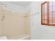 Bright bathroom featuring a tiled shower, a window with wood shutters, and a showerhead for a relaxing experience at 605 Ronele Dr, Brandon, FL 33511