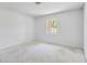Bright bedroom featuring white walls, one window offering natural light, and concrete floors ready to be transformed at 605 Ronele Dr, Brandon, FL 33511