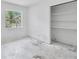 Bright bedroom featuring a window and closet space, offering natural light, and concrete floors ready to be transformed at 605 Ronele Dr, Brandon, FL 33511