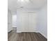 Bright bedroom featuring a comfortable bed, ample closet space, and wood-look floors at 6509 W Longboat Blvd, Tampa, FL 33615