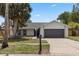 This exterior shot highlights the home's front yard, driveway, and curb appeal at 6509 W Longboat Blvd, Tampa, FL 33615