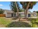 This exterior shows the front of the home with mature palm trees and garden at 6509 W Longboat Blvd, Tampa, FL 33615