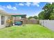 A spacious fenced backyard features a covered patio with a grill and outdoor seating at 6801 Summer Cove Dr, Riverview, FL 33578