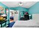 Bright bedroom with blue walls, posters, and a doorway to the living room, offering a unique and vibrant space at 6801 Summer Cove Dr, Riverview, FL 33578