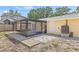 An exterior view of the home showing the backyard, a screened-in porch, and a small patio area made from pavers at 6807 River Rd, Tampa, FL 33615