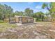 The spacious backyard with a screened-in lanai and carport features a large yard, and mature trees at 6807 River Rd, Tampa, FL 33615