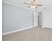 Bright bedroom features a ceiling fan, neutral paint, and durable tile flooring, creating a comfortable living space at 6807 River Rd, Tampa, FL 33615