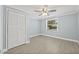 Light bedroom with closet and updated ceiling fan. Neutral paint and tile floor create a clean and modern aesthetic at 6807 River Rd, Tampa, FL 33615