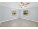 Sunlit bedroom with neutral paint, tile floors, ceiling fan, and bright windows at 6807 River Rd, Tampa, FL 33615