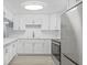 Updated kitchen with white cabinets, countertops, and stainless steel appliances at 6807 River Rd, Tampa, FL 33615
