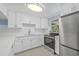 Updated kitchen with white cabinets, countertops, and stainless steel appliances at 6807 River Rd, Tampa, FL 33615