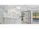 Updated kitchen with white cabinets, stainless steel appliances and view to the back patio at 6807 River Rd, Tampa, FL 33615