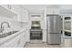 Updated kitchen featuring stainless steel appliances, white cabinets, and a sink at 6807 River Rd, Tampa, FL 33615