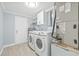 Clean laundry area with modern washer, dryer, shelving, and mechanical equipment at 6807 River Rd, Tampa, FL 33615