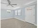 Bright living room featuring modern flooring, a ceiling fan, and large windows, creating a welcoming atmosphere at 6807 River Rd, Tampa, FL 33615