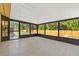 Screened in porch, tile flooring and view of the wooded back yard at 6807 River Rd, Tampa, FL 33615