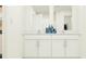 Modern bathroom with double vanity, white cabinets, and stylish decor, enhancing the space's functionality and appeal at 7758 Painted Sky Pl, Land O Lakes, FL 34637