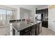Kitchen island features a stainless steel dishwasher, sink, granite countertop, and dark cabinets at 7916 Evergreen Creek Ct, Riverview, FL 33578