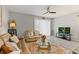 Open-concept living room featuring tile floors, a ceiling fan, comfortable leather couches, and ample natural light at 7916 Evergreen Creek Ct, Riverview, FL 33578