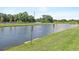 Scenic pond view with lush green landscaping and a warning sign for alligators at 7916 Evergreen Creek Ct, Riverview, FL 33578