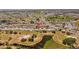 An aerial view of a single story home in a quiet residential neighborhood with mature trees and nearby golf course and water features at 828 Fox Hills Dr, Sun City Center, FL 33573