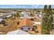Aerial view of a single-Gathering home with a well-kept lawn, mature landscaping, and a chain-link fence at 828 Fox Hills Dr, Sun City Center, FL 33573