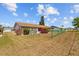 Home's backyard with a chain-link fence, lawn, and a flower bed next to the house at 828 Fox Hills Dr, Sun City Center, FL 33573