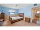 Comfortable bedroom featuring blue upper walls, a wood frame bed, and a ceiling fan for a relaxing atmosphere at 828 Fox Hills Dr, Sun City Center, FL 33573