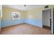 Well-lit bedroom with a window and yellow upper walls complemented by blue trim and wood floors at 828 Fox Hills Dr, Sun City Center, FL 33573
